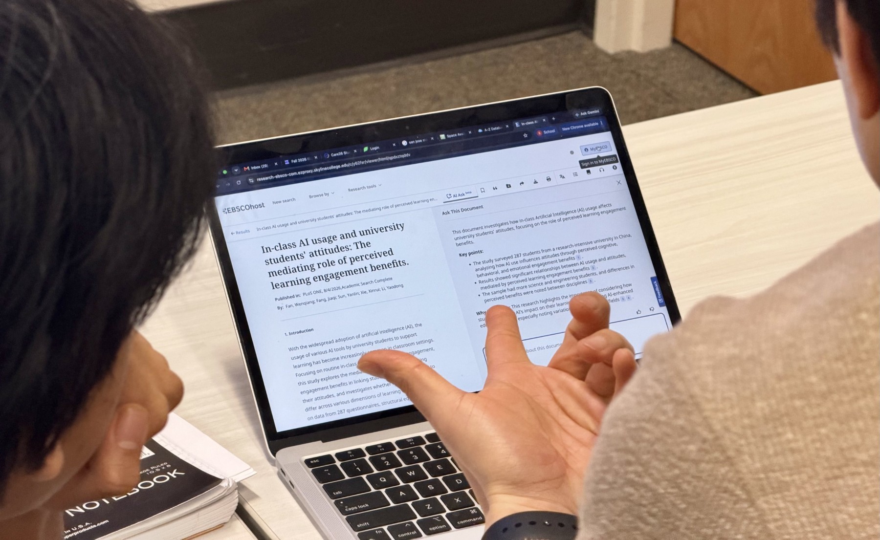 Reviewing a scholarly article about AI use together in EBSCOhost during a student consultation