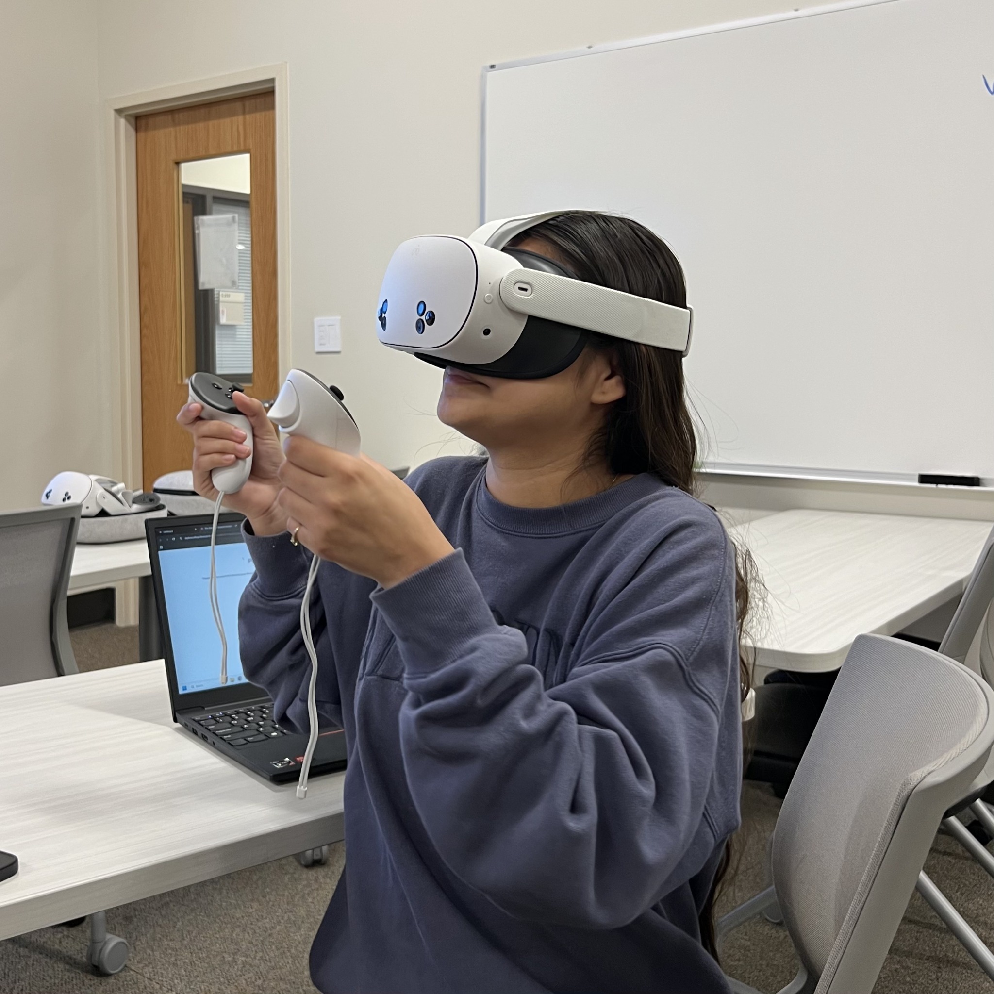 A participant exploring a VR experience using a headset and two controllers