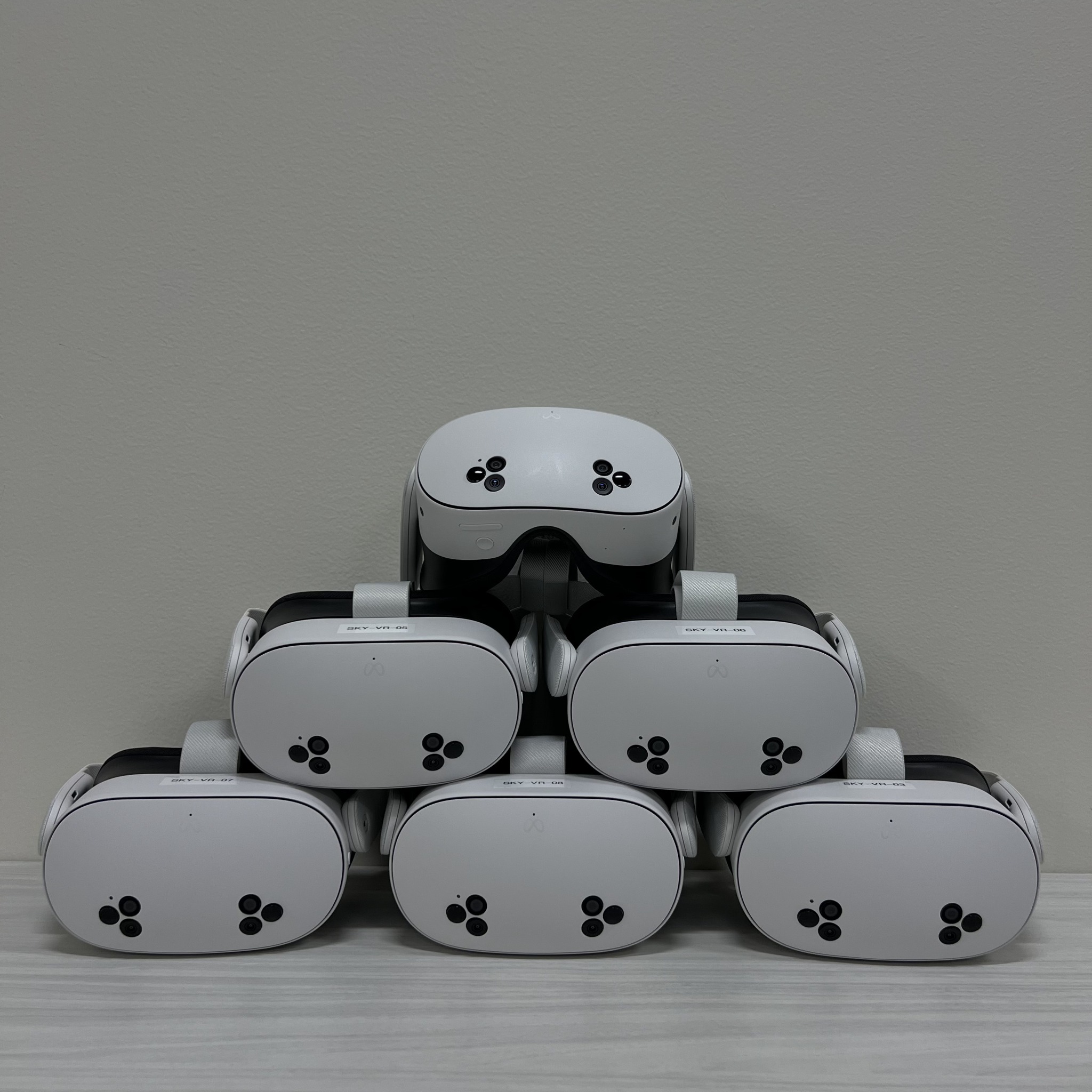 Six VR headsets arranged together on a table